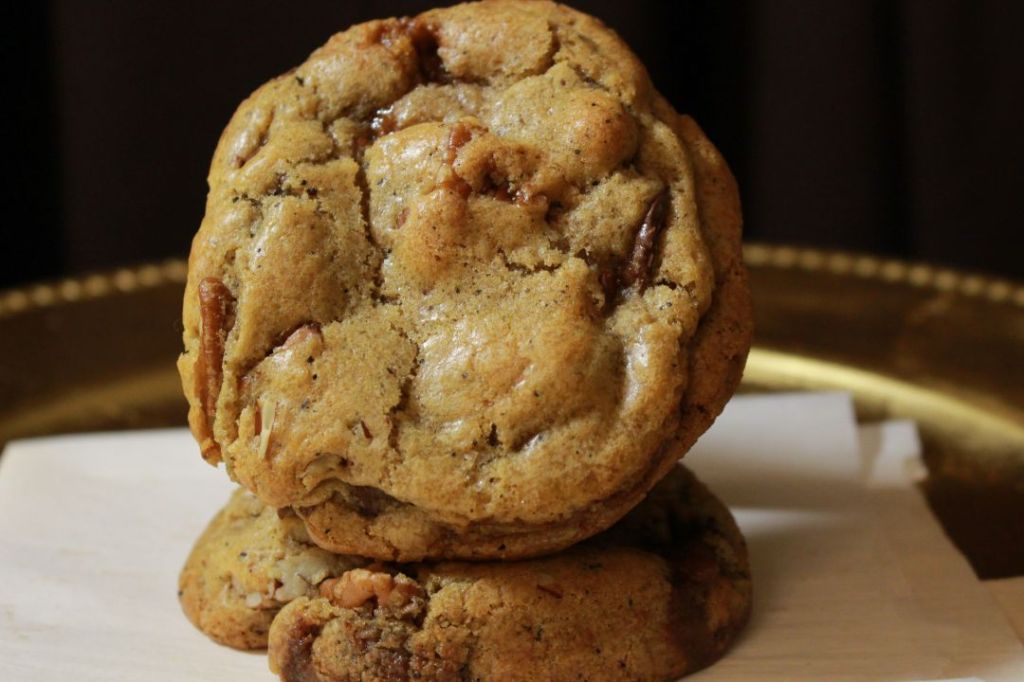 Photo of cookie with earl grey specks, pecan, chocolate chips, and toffee propped on another cookie